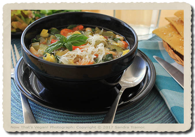 A hardy soup containing vegetables, gluten-free pasta, and beans.